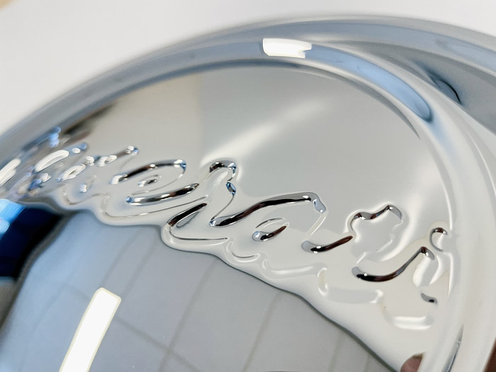 Detail van een gepolijst verchroomd Maserati-wieldop
