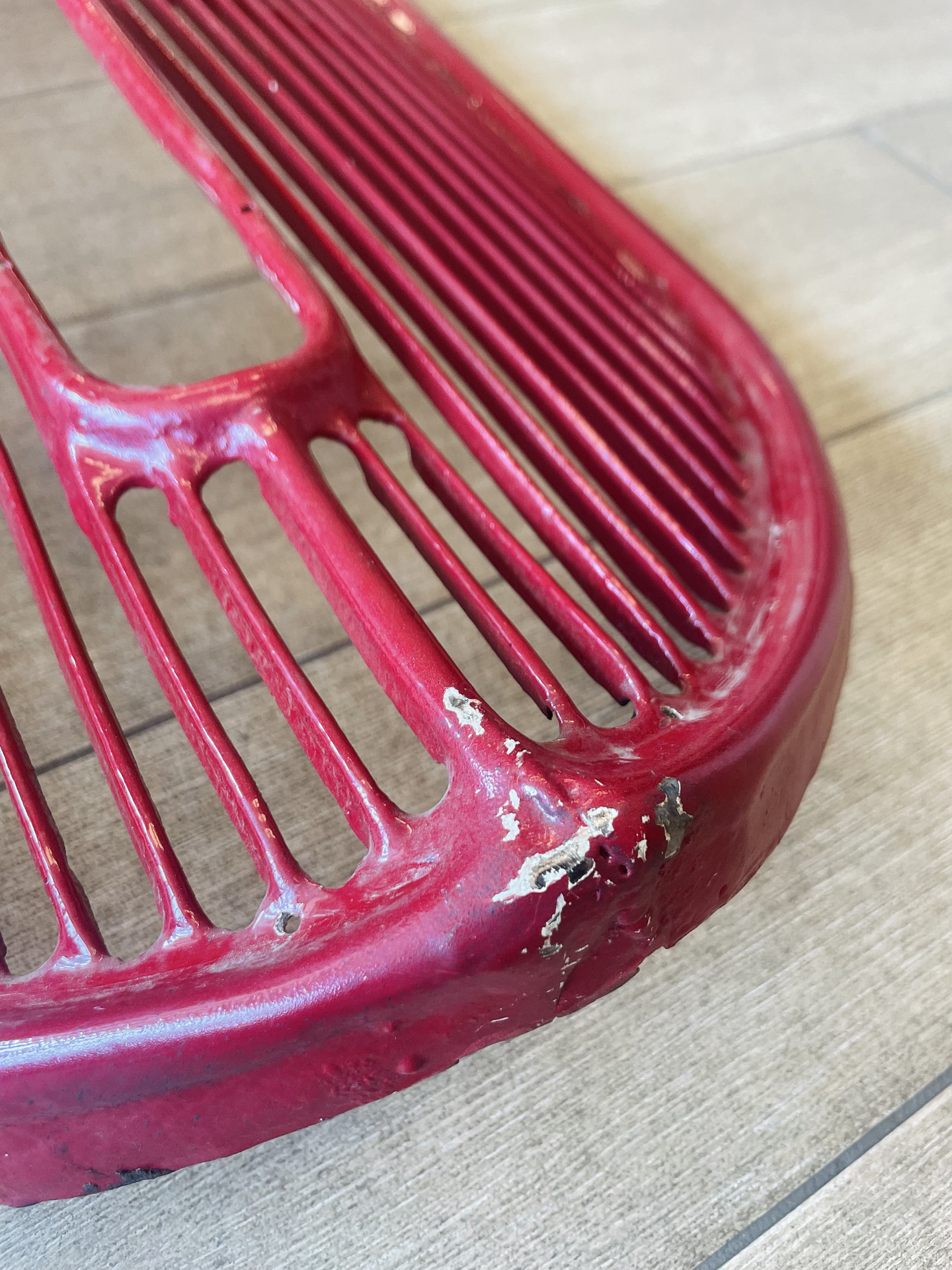 Grille van een Citroën in de uitgangssituatie, met de oude rode verflaag en aantasting